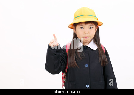 Kleine asiatische Schulmädchen Aufstieg Hand und zeigt Stockfoto