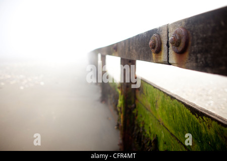 Nebel Wolken Sandown Beach auf der Isle Of Wight. Hölzerne Buhnen verschwinden in der niedrigen Wolken im englischen Badeort. Stockfoto