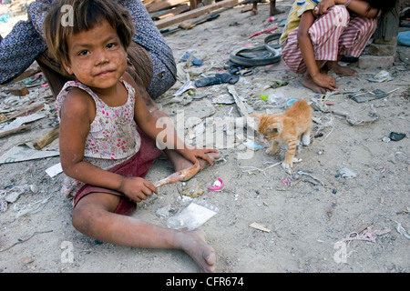 Ein junges Mädchen spielt mit einer Katze im neuen Zuhause bei der toxischen Stung Meanchey Mülldeponie in Kambodscha Phnom. Stockfoto