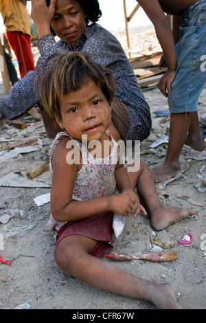 Eine junges Kind Arbeiter Mädchen sitzt mit ihrer Familie in ihrem neuen Zuhause bei der Stung Meanchey Mülldeponie in Kambodscha Phnom. Stockfoto