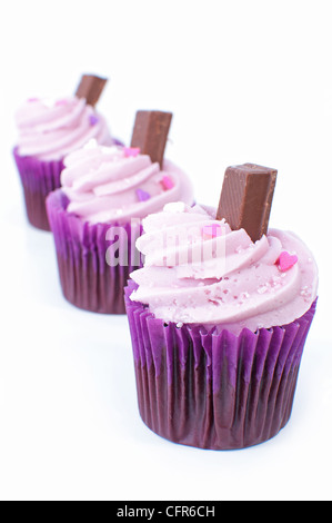 Leckere rosa Muffins auf einem weißen Hintergrund mit einer Tafel Schokolade Stockfoto