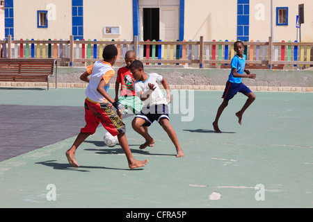 Jungen Fußball spielen barfuß auf dem Kinderspielplatz in der Hauptplatz. Sal Rei, Boa Vista, Kap Verde Inseln, Afrika Stockfoto