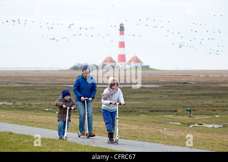eine Mutter und ihre Kinder ein Motorroller vor Leuchtturm Westerhever, Schleswig-Holstein, Deutschland Stockfoto