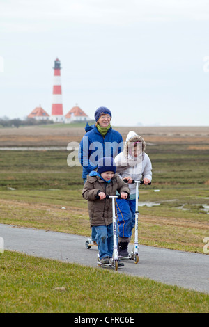 eine Mutter und ihre Kinder ein Motorroller vor Leuchtturm Westerhever, Schleswig-Holstein, Deutschland Stockfoto