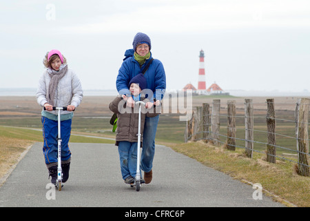 eine Mutter und ihre Kinder ein Motorroller vor Leuchtturm Westerhever, Schleswig-Holstein, Deutschland Stockfoto