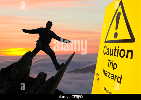 Harter fiel über den Wolken auf nassen Seitenkante im Lake District und eine Silhouette Kletterer. Stockfoto