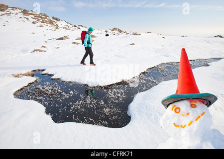 Frau Hill Wanderer von einem gefrorenen Moor in der Nähe von scheut Tarn in die saisonabhängige, Lake District, Großbritannien Stockfoto