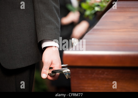 Religion, Tod und Dolor - Sarg Träger tragen die Schatulle bei Beerdigung, Friedhof Stockfoto