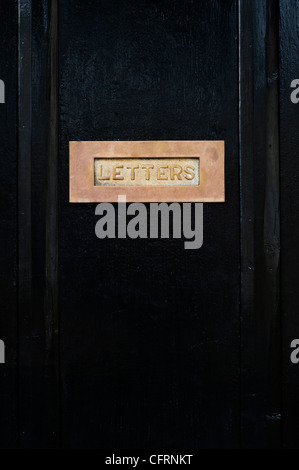 Messing Buchstaben auf schwarzem Holz Tür. Cotswolds, Großbritannien