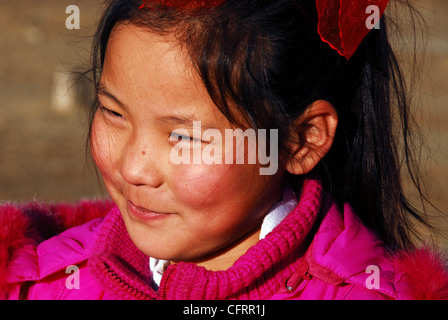 Mongolei, Baganuur, Nahaufnahme von einem netten asiatischen Mädchen wegsehen und lächelnd Stockfoto