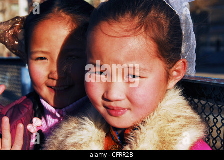 Mongolei, Baganuur, close-up Portrait von einem asiatischen Mädchen lächelnd, während ein Mädchen von hinten spähen Stockfoto