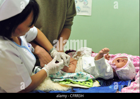 Mongolei, Baganuur, Krankenschwester, eine Injektion geben, um einem Neugeborenen baby Stockfoto