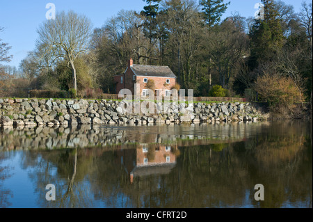 Riverside Cottage mit Reflexion in frühen Frühlingssonne am Fluss Wye bei Hay on Wye Powys Wales UK Stockfoto