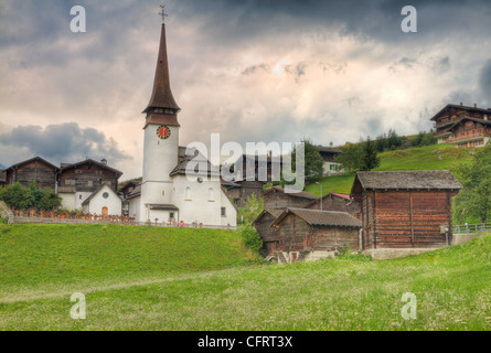 kleines Schweizer dörfliche Siedlung von verwelkten Holzhäusern und Kirche im Kanton Wallis Schweiz Stockfoto