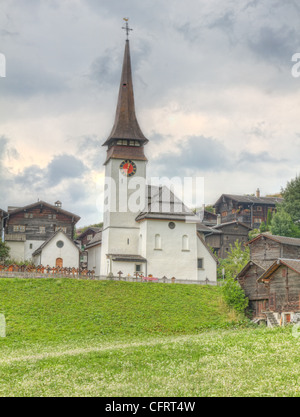 kleines Schweizer dörfliche Siedlung von verwelkten Holzhäusern und Kirche im Kanton Wallis Schweiz Stockfoto