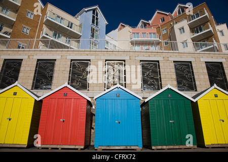 Hell gefärbt Strandhütten und Neubau Wohnungen und Appartements an der Strandpromenade in Boscombe in der Nähe von Bournemouth, Dorset Stockfoto