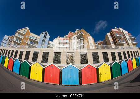 Hell gefärbt Strandhütten und Neubau Wohnungen und Appartements an der Strandpromenade in Boscombe in der Nähe von Bournemouth, Dorset Stockfoto