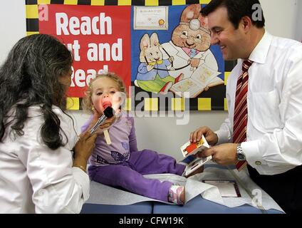 29. Januar 2007 hat - Delray Beach, FL, USA - Staat repräsentative ADAM HASNER, Recht, um eine Pause zu ANGELINA MAZZA, 2, ein Buch zu lesen, während Dr. SUBHASHINI YALAMANCHI Kehle einen Blick auf das Gesundheitszentrum Delray Beach Dienstag, 30. Januar 2007 gibt. Das Gesundheitszentrum verschenkte etwa 1.100 Bücher Stockfoto