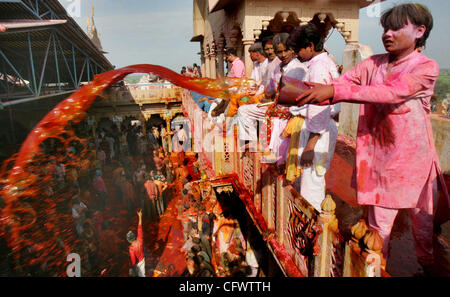 Indischer Mann wirft Farbe auf die Gläubigen im Laduji Tempel während der Feier des Holi-Fest in der nördlichen Dorf Barsana, Mathura, auf Sonntag, 25. Februar 2007. In Barsana feiern die Menschen eine Variation von Holi, das hinduistische Frühlingsfest Farben, genannt 'Lathmaar' Holi, was bedeutet, dass sein Stockfoto