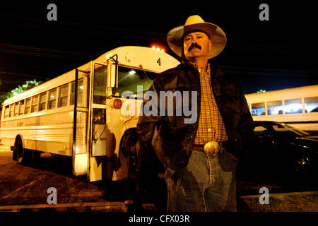 März 15, 2007 Calexico, CA JOSE MORENO, Vorarbeiter für El Don Farm Arbeit Contracting, Inc., steht vor einer weißen Bus er fahren; einer von vielen, die Linie einen Parkplatz in Calexico, Kalifornien am 04:30, auf der Seite der Vereinigten Staaten der USA / Mexiko Grenzübergang von Mexicali, Baja California. Stockfoto