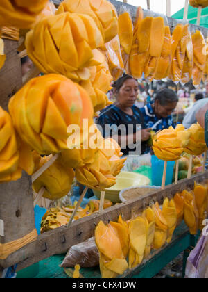 Antigua, Guatemala. 23.03.07 geschnittene frisch Früchte auf Sticks für Verkauf Kontrast mit westlichen alkoholfreie Getränke im Markt Stadt. Stockfoto