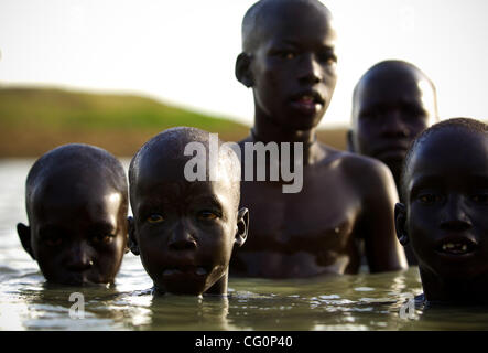 11. Juli 2007 - Kolmerek, Süd-Sudan - Zugang zu diesen saisonalen Wasserloch liefert notwendige Trinkwasser für das Vieh und die Menschen und dienen als eine bequeme Möglichkeit, erfrischen Sie sich von den 120 plus Grad Hitze. Eines der Highlights des Tages von einem jungen Dinka in der Vieh-Camp ist erlaubt Stockfoto