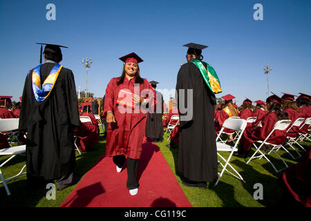 Tragen ihr neues Diplom, marschiert stolz Hispanic Oberstufenschüler zu ihrem Platz während der Abschlussfeier in Huntington Beach, Kalifornien. Stockfoto