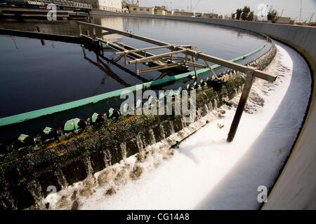 Ein Rotary-kehren "rieselnde Filter Nachklärbecken" schöpft Schaum von der Oberfläche des Abwassers in ein Absetzbecken in einer Wasseraufbereitungsanlage in Fountain Valley, Kalifornien. Stockfoto