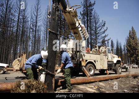 Von links arbeiten Apprentice Lineman Jon McCue und Lineman Justin Wearin von Sierra Pacific Power Company um Stromleitungen in einem stark verbrannte Fläche zu ersetzen, nachdem ein massives Feuer durch die South Lake Tahoe Gegend seit Sonntag kopiert.  Foto 29. Juni 2007.  Herbst-Cruz / Sacramento Bee ist Tahoe Tanne Stockfoto