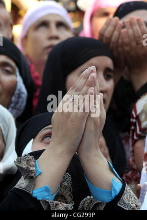 Ein Kaschmir muslimische Frau während betet als Hauptpriester (nicht im Bild) zeigt die heilige Reliquie, geglaubt, um Haare aus dem Bart des Propheten Mohammad, während spezielle Gebete, die Märtyrer-Tag von Hazrat Ali, Cousin des Propheten Mohammad, am 21. Tag des Ramadan, an die Hazratbal zu beobachten Stockfoto