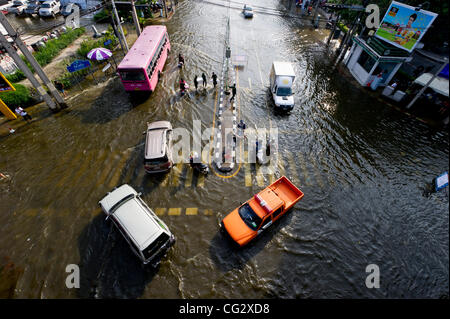 4. November 2011 wie sie kriechen weiter - Bangkok, Thailand - Leute fahren und zu Fuß durch Hochwasser in der Innenstadt. Thailand ist Leiden von ist es schlimmsten Überschwemmungen seit 50 Jahren. Seit Ende Juli nach Abteilung Katastrophenschutz und Minderung sind rund 430 Menschen gestorben. (Cred Stockfoto