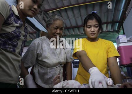 22. August 2012 - Mae Sot, Thailand - burmesischen Migranten suchen Immunisierung für ihre Kinder in Mae Tao Klinik in der Nähe von Mae Sot, Thailand, Mittwoch, 22. August 2012.  Wegen der jüngsten Schritte von International Non-Governmental Organizations-Bewegungen in Burma ist die Mae Tao Klinik, die medizinische Versorgung rund 500 burmesischen Migranten pro Tag zur Verfügung stellt, mit Finanzierungsproblemen konfrontiert. 1989 war von ethnischen Karen Arzt Dr. Cynthia Maung die Klinik als direkte Antwort auf die Bedürfnisse von Tausenden von Flüchtlingen gegründet, die nach Thailand geflohen waren nach einer gewaltsamen Vorgehens gegen prodemokratischen Demonstrationen in Rangoo Stockfoto