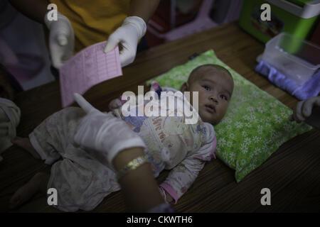 22. August 2012 - Mae Sot, Thailand - burmesischen Migranten suchen Immunisierung für ihre Kinder in Mae Tao Klinik in der Nähe von Mae Sot, Thailand, Mittwoch, 22. August 2012.  Wegen der jüngsten Schritte von International Non-Governmental Organizations-Bewegungen in Burma ist die Mae Tao Klinik, die medizinische Versorgung rund 500 burmesischen Migranten pro Tag zur Verfügung stellt, mit Finanzierungsproblemen konfrontiert. 1989 war von ethnischen Karen Arzt Dr. Cynthia Maung die Klinik als direkte Antwort auf die Bedürfnisse von Tausenden von Flüchtlingen gegründet, die nach Thailand geflohen waren nach einer gewaltsamen Vorgehens gegen prodemokratischen Demonstrationen in Rangoo Stockfoto