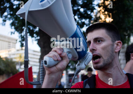 Junger Mann mit Megaphon führt Demonstranten in rief Parolen gegen einen Militärschlag gegen den Iran und gegen die Regierung außerhalb der PM-Residenz. Jerusalem, Israel. 23. August 2012.  Einige fünfzig Demonstranten vor Amtssitz des Premierministers fordern PM Benjamin Netanyahu und Verteidigungsminister Ehud Barak Absichten des militärischen Angriff auf die iranischen Atomanlagen fallen zu lassen. Stockfoto