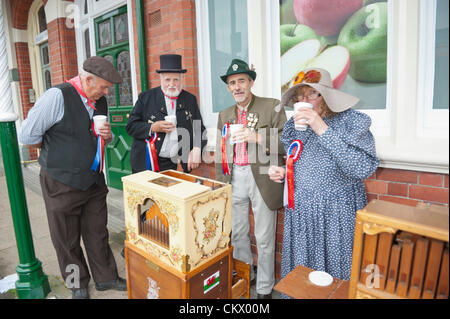 24. August 2012. Llandrindod Wells, Wales, UK. Paul (links) und Dorothy McCarthy (rechts) von Basingstoke UK Trevor Taylor (2. von links) und David Hatfield (3. von links) sowohl von Aberystwyth, Wales UK. Schutz für eine Teepause um Davids 20er (spielt 20 Töne) deutsche Raffin Street Organ. Photo Credit: Graham M. Lawrence. / Alamy Live News. Stockfoto