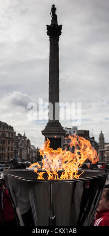 London, UK. Freitag, 24. August 2012. Die Paralympische Flamme brennt in den Kessel auf dem Trafalgar Square mit der Nelson Säule in den Hintergrund. Stockfoto