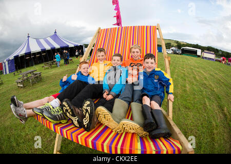 Kinder spielen auf riesige Liegestuhl am Abend Eröffnung von "The Big Tribute" Festival in Lovesgrove Aberystwyth Wales UK. Wales nur Festival mit ausschließlich Tribut Gruppen Stockfoto