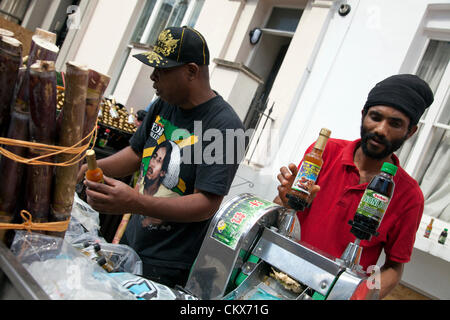 26. August 2012, Sonntag, Nottinghill Carnival Nottinghill Gate, London, UK - 12,50 H - einheimischen Zuckerrohrsaft herstellen und verkaufen auf der Straße. Bildnachweis: Miguel Sobreira / Alamy Live News Stockfoto