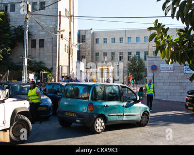 27. August 2012. Eltern tragen helle Westen freiwillig bei der Verkehrsüberwachung und Kursteilnehmer sicheren Zugang auf Bet-Hakerem Grundschule am ersten Tag des laufenden Schuljahres. Jerusalem, Israel. 27. August 2012.   Israelische Kinder gehen wieder zur Schule heute, Abschaffung der traditionellen Sept. 1. Datum, in einer ersten Stufe des Ministeriums für Bildung mit dem Ziel, die Sommerferien 6 Wochen verkürzen eingeleiteten Reformen teilweise entlastet Eltern enorme finanzielle Aufwendungen. Stockfoto