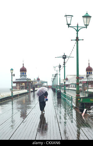 27. August 2012 gehalten nassen und windigen Wetter in Blackpool an den letzten Sommer Feiertag des Jahres die Urlaub Massen entfernt. Frauen kämpfen ihren Weg entlang der North Pier. Bildnachweis: Kevin Walsh / Alamy Live News Stockfoto