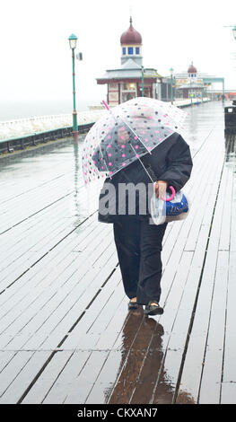 27. August 2012 gehalten nassen und windigen Wetter in Blackpool an den letzten Sommer Feiertag des Jahres die Urlaub Massen entfernt. Frauen kämpfen ihren Weg entlang der North Pier. Bildnachweis: Kevin Walsh / Alamy Live News Stockfoto