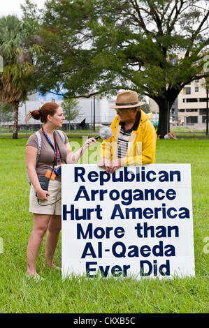 27. August 2012 - Tampa, FL, USA - Personen Zeichen in einem Park, wo 5.000 Demonstranten erwartet wurden, um für den "Marsch auf die RNC" am Morgen von dem geplanten Beginn der Republican National Convention 2012 zu sammeln.  Die tatsächliche Demonstrant Wahlbeteiligung war aufgrund Tropensturm Warnungen ein paar hundert. Stockfoto