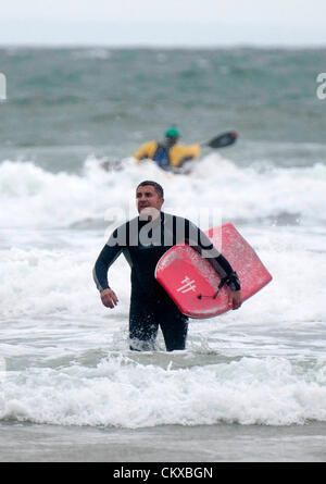 Bank Holiday beach Wetter - Caswell Bucht - Swansea - UK 27. August 2012: ein Bodyboarder, seinen Weg in die Brandung an der Caswell Bucht in der Nähe von Swansea heute Nachmittag. Stockfoto