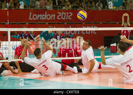 Männer sitzen Volleyball-Spiel zwischen Marokko (weiß) und Ägypten (rot) bei Paralympics London 2012. Stockfoto