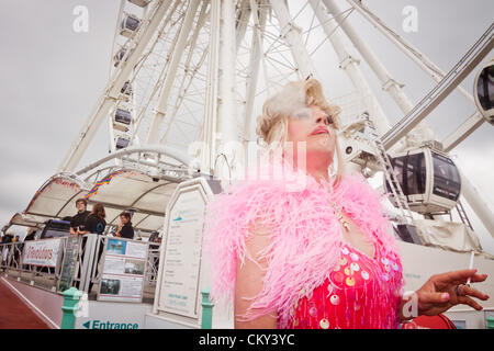 Brighton, Großbritannien 1. September 2012. Ein Transvestit raucht eine Zigarette während der Gay Pride Parade beobachten. Stockfoto