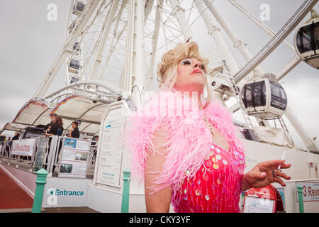 Brighton, Großbritannien 1. September 2012. Ein Transvestit raucht eine Zigarette während der Gay Pride Parade beobachten. Stockfoto