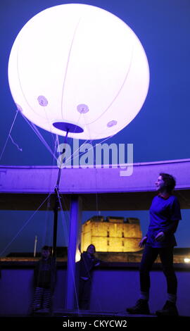 Carlisle, UK. 1. September 2012. Die Verbindung Licht-Kunst-Installation von New York basierte digitale Kunst kollektive YesYesNo. Einige 400 Wetterballons mit pulsierenden farbigen LED-Leuchten wurden an verschiedenen Standorten über die 73 Meilen von Hadrian Wand installiert. Hier ein Mitglied der Öffentlichkeit Ansichten eines der Lichter auf der Rotunde im Tullie House Art Gallery and Museum in Carlisle, Cumbria, das zusammen mit Carlisle Castle in der Nähe der Linie der Hadrianswall liegt positioniert: 1. September 2012 STUART WALKER Stockfoto