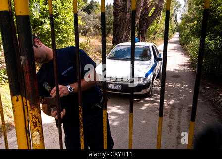 Polizist, öffnen das Tor - Tatoi war ursprünglich die Sommerresidenz des griechischen Königshauses die schließlich als ganzjährig zuhause genutzt wurde und der Geburtsort von König George II. Das Anwesen liegt ca. 20 km nördlich von Athen in der Nähe von Dekeleia. Ca. 1km vom wichtigsten Residency ist der griechischen königlichen Friedhof. Das Anwesen gehört auch die königliche Höfe. Fotos aus dem Jahr 2008. 3. September 2012. Athen, Griechenland. Die griechische Regierung in dieser Woche angekündigt, dass die ehemaligen königlichen Anwesen Tatoi war gesetzt werden für Verkauf oder Vermietung von der Privatisierung Staatsfonds (TAIPED). Stockfoto
