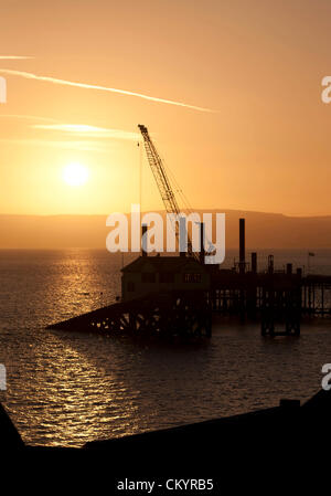 5. September 2012 - Swansea - UK: die Sonne steigt über den legendären murmelt Pier und Rettungsboot station heute Morgen auf die neue £9,5 Millionen RNLI murmelt Rettungsstation am Ende des Piers Weiterarbeit. Der neue Bahnhof wird gebaut, um das neue Tamar Klasse Rettungsboot aufnehmen, die eine Höchstgeschwindigkeit von 25knots hat — acht schneller als das aktuelle Tyne-Klasse-Schiff – und ist auch etwas länger. Stockfoto