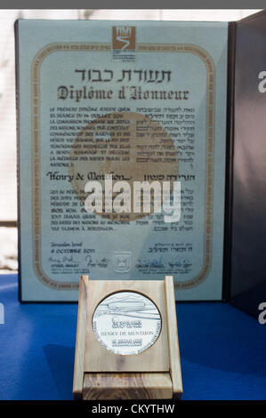 Jerusalem, Israel. 5. September 2012. Urkunde und Medaille zu Ehren Graf Henry de Menthon als Gerechte unter den Völkern, Enkel, Olivier de Menthon, bei einer Zeremonie im Yad Vashem Holocaust Museum präsentiert. Jerusalem, Israel. 5. September 2012.  Yad Vashem hält eine Zeremonie, die posthum ehrt Graf Henry de Menthon als Gerechte unter den Völkern. Die Veranstaltung findet im Beisein der Überlebende Dina Godschalk und französischer Botschafter in Israel er Christoph Bigot, Familie und Freunde. Stockfoto